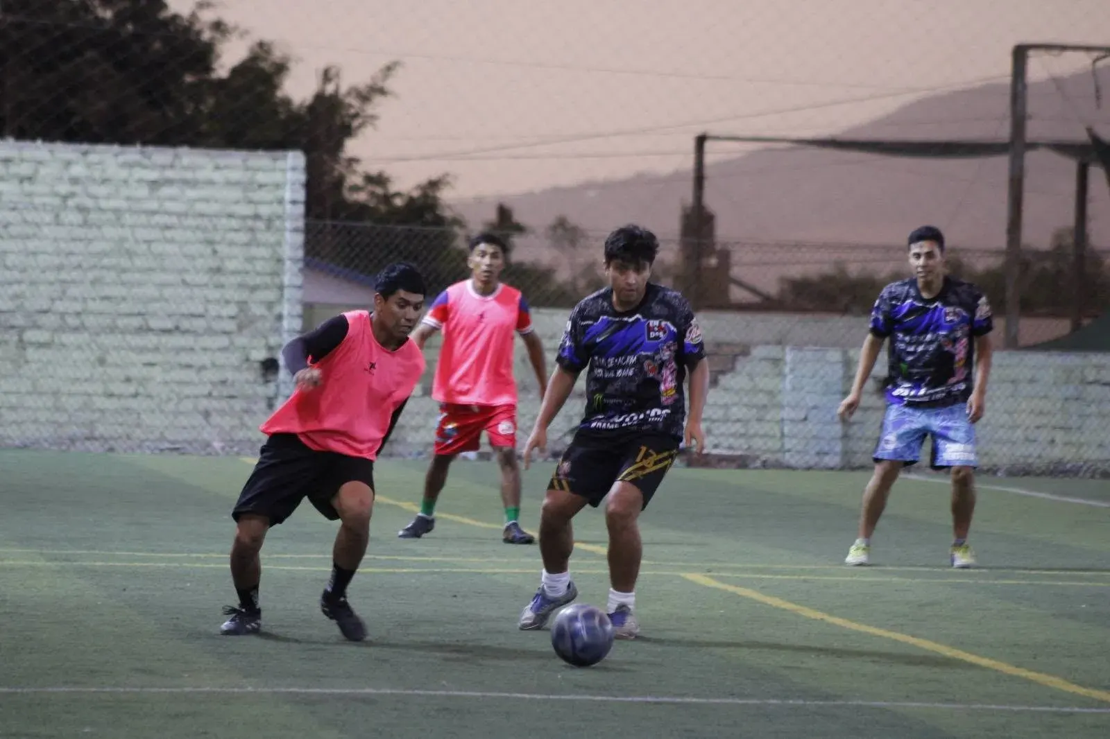 Jugador avanzando con el balón frente a un rival