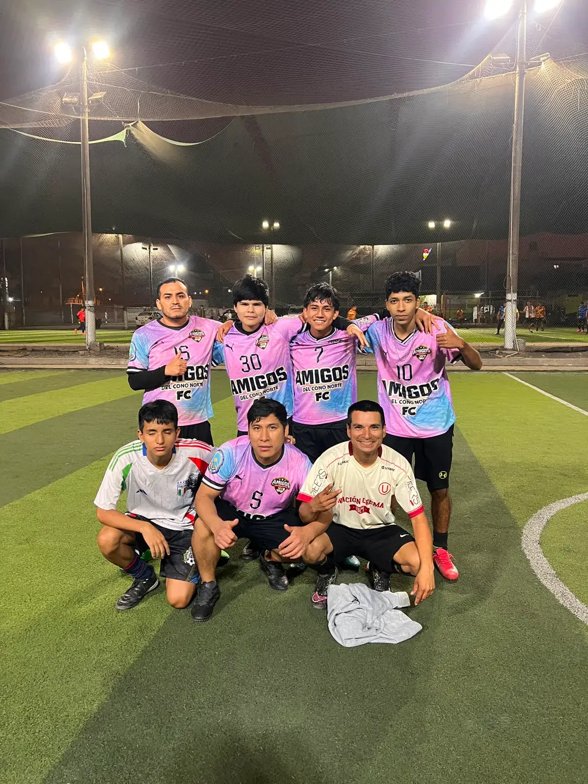 Jugadores de Amigos del Cono Norte reunidos en una cancha de fútbol